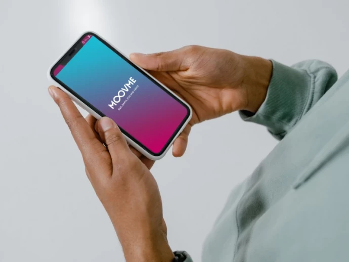 Hände halten ein Smartphone mit MOOVME App auf dem Bildschirm