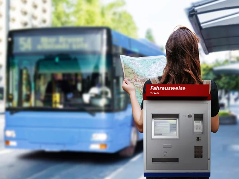 Frau mit Ticketautomaten als Rucksack an einer Bushaltestelle