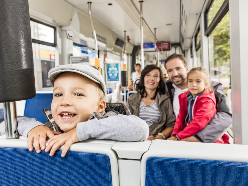 4-köpfige Familie sitzt in der Straßenbahn