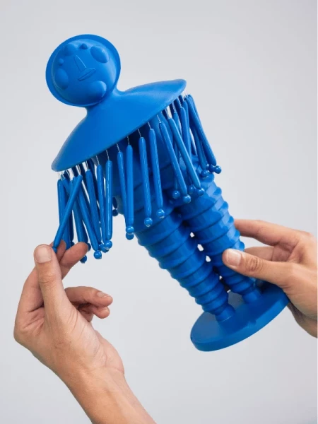 Hände befühlen eine blaue Figur