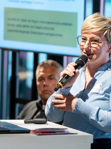 Blonde Frau hinter einem Rednerpult