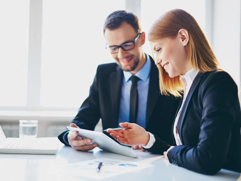 Menschen in formeller Kleidung sitzen am Tisch und tauschen sich aus
