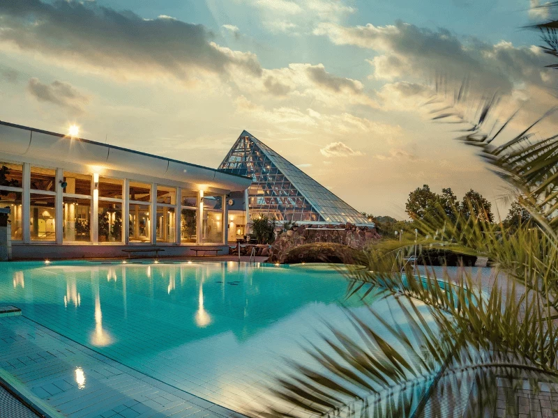 Außenbecken mit Glaspyramide im Sonnenuntergang