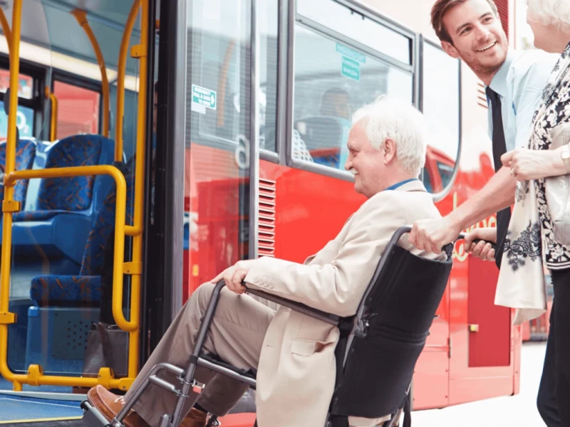 Ältere Person im Rollstuhl wird in die Bahn geschoben