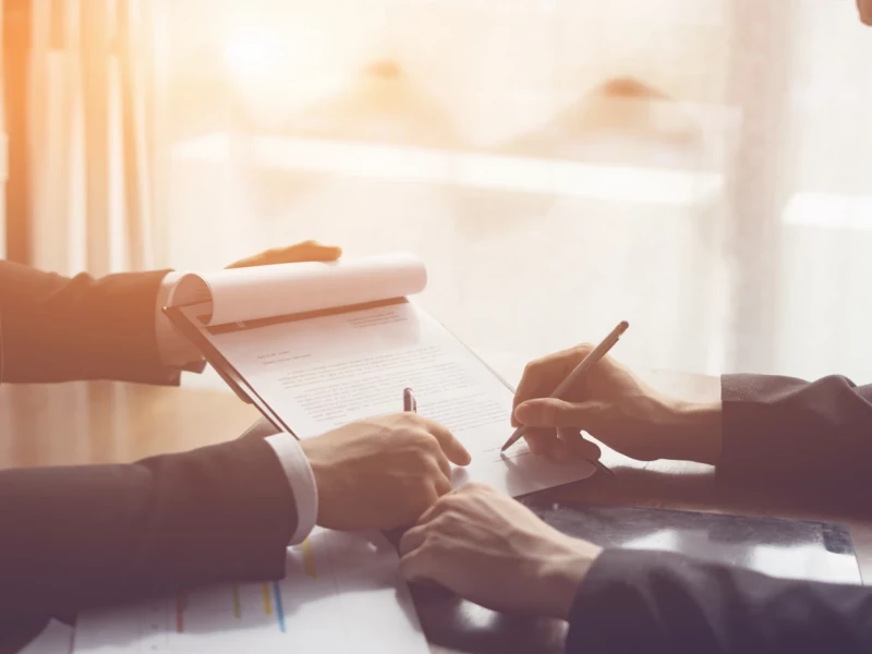 Zwei Personen unterzeichnen einen Vertrag.