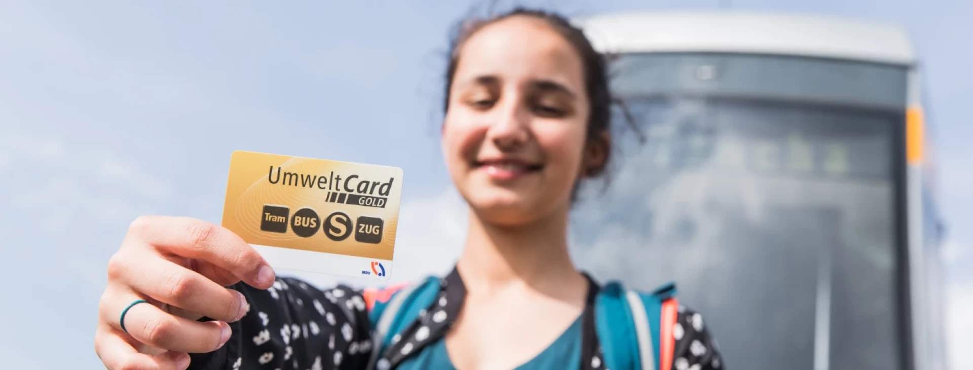 Junge Frau hält UmweltCardGOLD in die Kamera