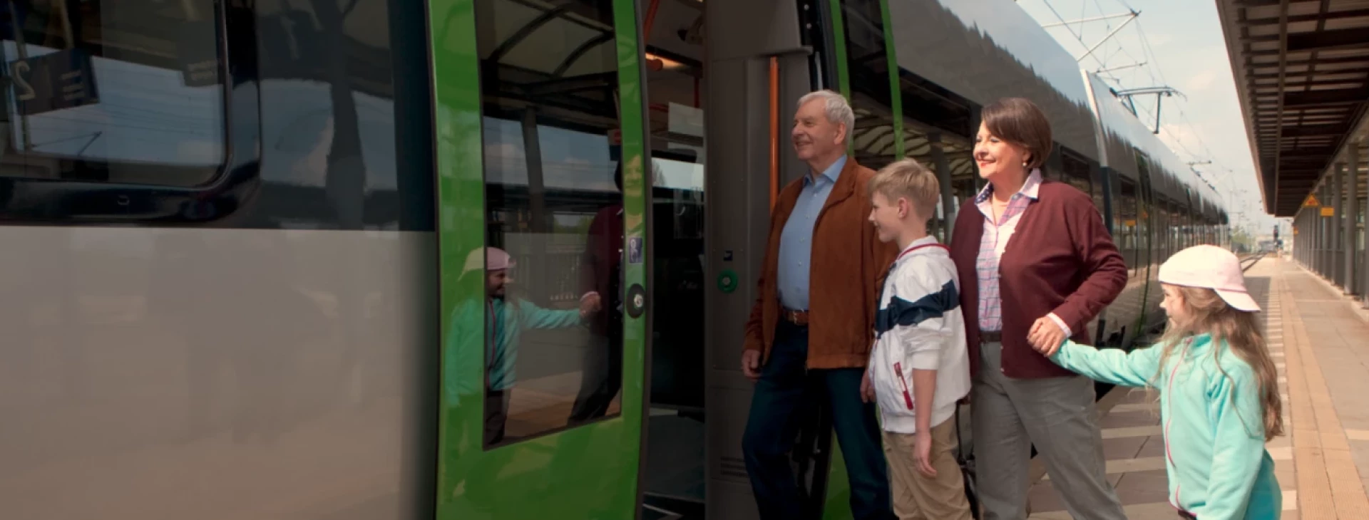 Eine Familie steigt gut gelaunt in eine S-Bahn ein.