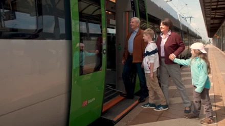 Eine Familie steigt gut gelaunt in eine S-Bahn ein.