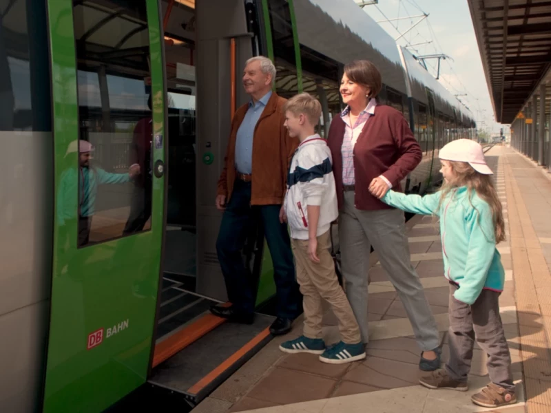 Eine Familie steigt gut gelaunt in eine S-Bahn ein.