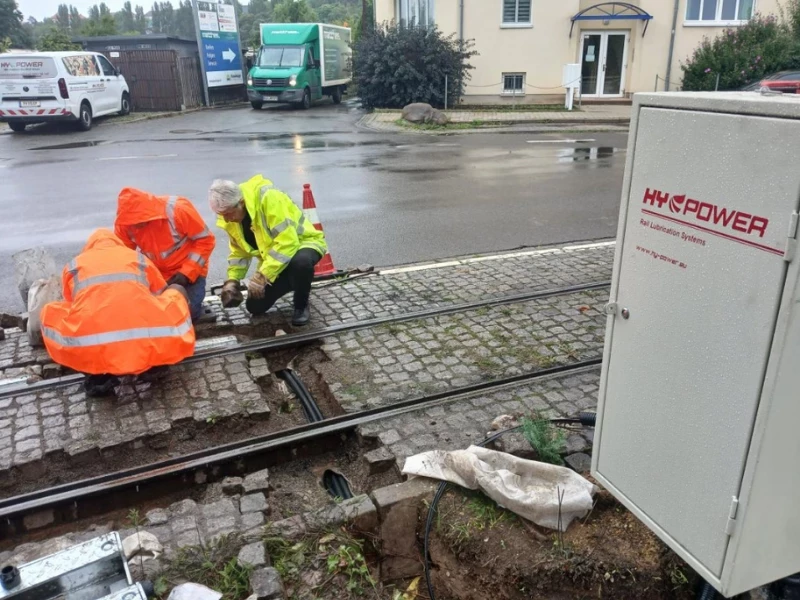 Eine Kurvenschmieranlage der Firma HY Power wird bei Regen in Naumburg eingebaut