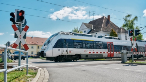 Zug, Schranke, rote Ampel, Haus im Hintergrund