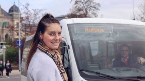 Frau vor Bus mit Anzeige RufBus Frau vor Bus mit Anzeige RufBus